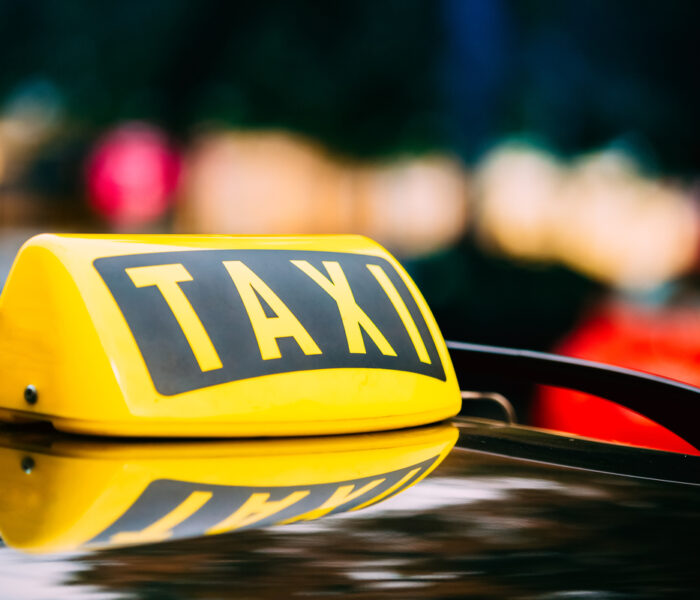 Panneau de taxi jaune sur le toit d'une voiture.